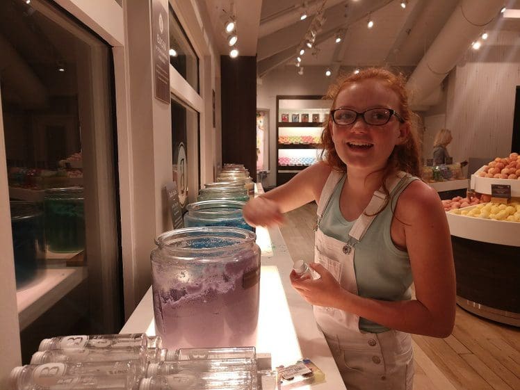 Teenage girl having fun at Basin Disney Springs, exploring handmade soaps and bath products in this Basin Disney Springs review