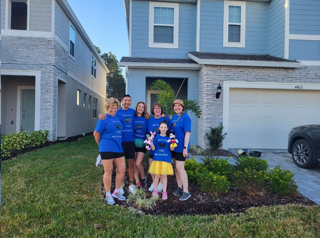 Our family standing in front of a beautiful house, enjoying our Florida vacation rental experience at Chillax Inn.