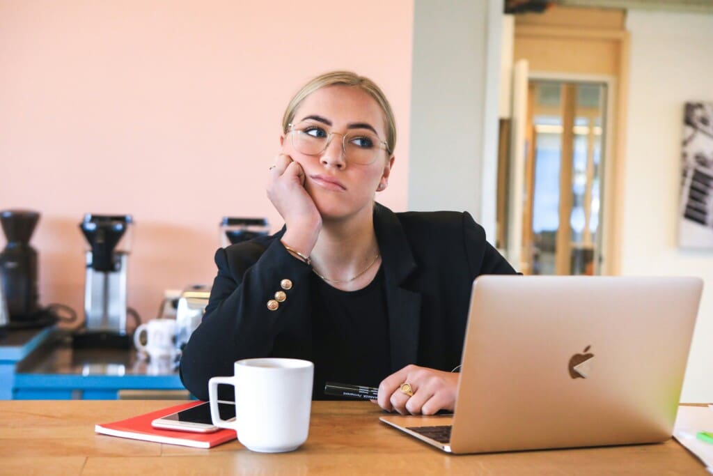 A woman in deep thought, contemplating whether to rent a vacation home in Orlando or stay in a hotel.