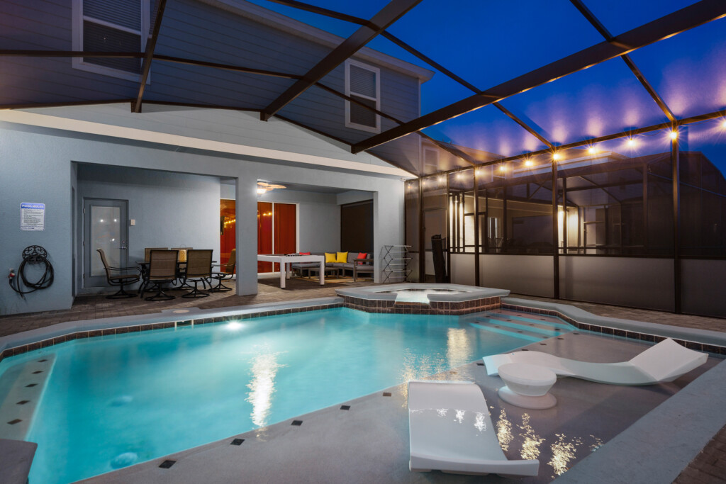 Luxury holiday villa rental Orlando featuring a private screened swimming pool and patio at night.