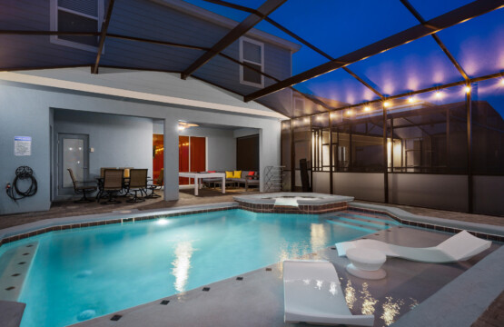 Luxury holiday villa rental Orlando featuring a private screened swimming pool and patio at night.